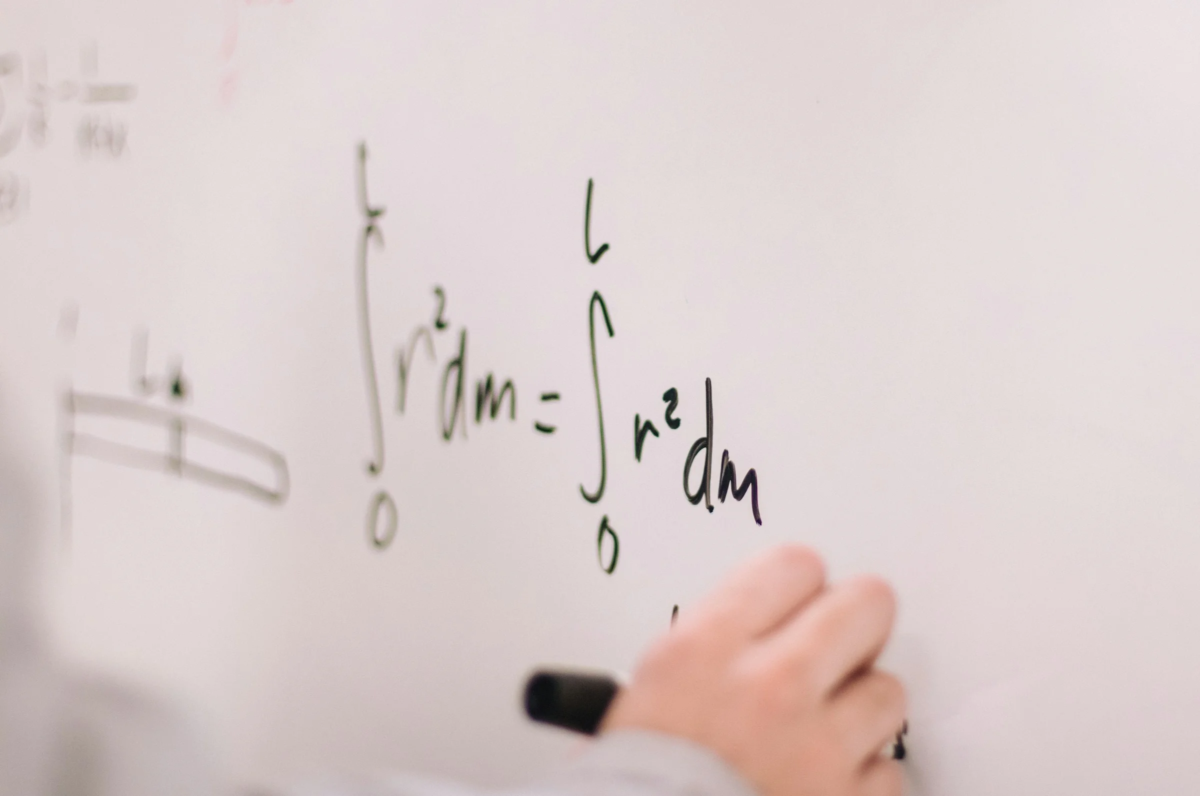 Equations being explained on a whiteboard